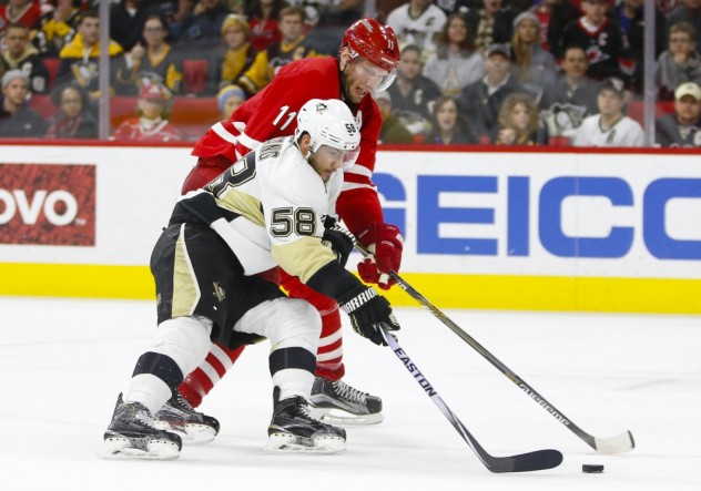 Jan 12, 2016; Raleigh, NC, USA;  Pittsburgh Penguins defensemen Kris Letang (58) and Carolina Hurricanes forward Jordan Staal (11) battle for the puck during the second period at PNC Arena. Mandatory Credit: James Guillory-USA TODAY Sports
