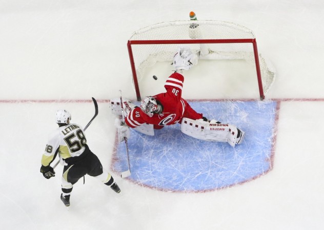 Feb 12, 2016; Raleigh, NC, USA;  Pittsburgh Penguins defensemen Kris Letang (58) scores the game winning goal during the shoot out against Carolina Hurricanes goalie Cam Ward (30) at PNC Arena. The Pittsburgh Penguins defeated the Carolina Hurricanes 2-1 in the shoot out. Mandatory Credit: James Guillory-USA TODAY Sports