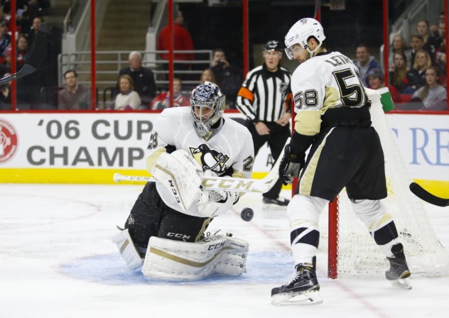 Feb 12, 2016; Raleigh, NC, USA;  Pittsburgh Penguins goalie Marc-Andre Fleury (29) clears the puck away next to defenseman Kris Letang (58) during the second period against the Carolina Hurricanes at PNC Arena. Mandatory Credit: James Guillory-USA TODAY Sports