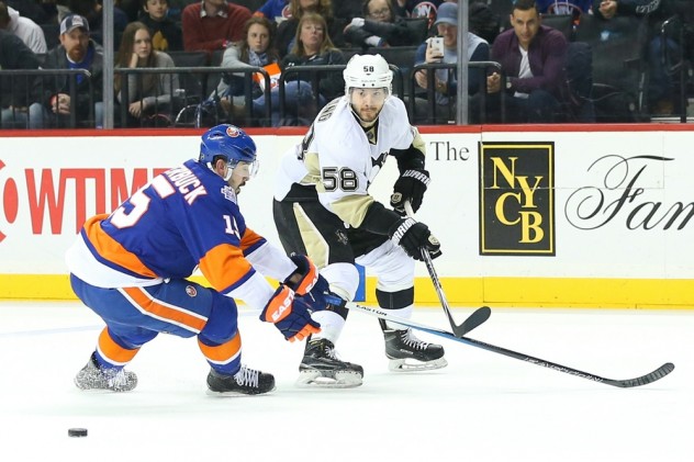 Apr 2, 2016; Brooklyn, NY, USA; Pittsburgh Penguins defenseman Kris Letang (58) puts a shot past New York Islanders right wing Cal Clutterbuck (15) during the third period at Barclays Center. Pittsburgh Penguins won 5-0. Mandatory Credit: Anthony Gruppuso-USA TODAY Sports