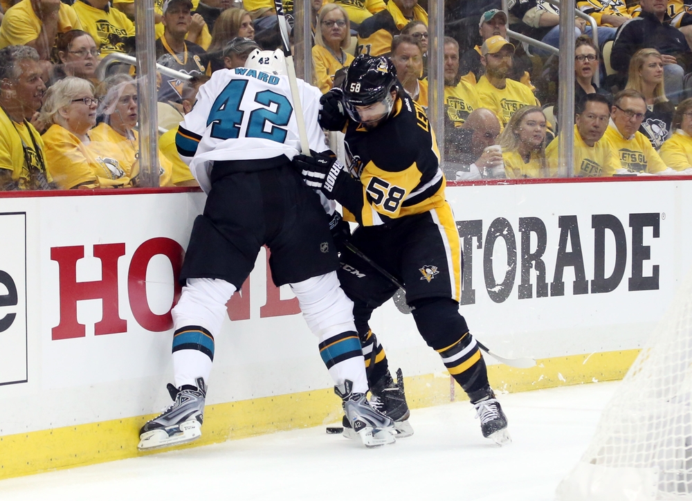 Jun 1, 2016; Pittsburgh, PA, USA; Pittsburgh Penguins defenseman Kris Letang (58) battles for the puck with San Jose Sharks right wing Joel Ward (42) in the first period of game two of the 2016 Stanley Cup Final at Consol Energy Center. Mandatory Credit: Charles LeClaire-USA TODAY Sports
