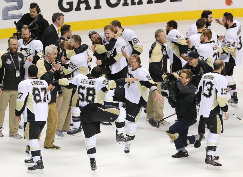 Jun 12, 2016; San Jose, CA, USA; Pittsburgh Penguins players including defenseman Kris Letang (58) and left wing Carl Hagelin (62) celebrate after defeating the San Jose Sharks in game six of the 2016 Stanley Cup Final at SAP Center at San Jose. Mandatory Credit: John Hefti-USA TODAY Sports