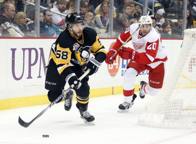 Dec 3, 2016; Pittsburgh, PA, USA; Pittsburgh Penguins defenseman Kris Letang (58) clears the puck ahead of Detroit Red Wings left wing Drew Miller (20) during the third period at the PPG PAINTS Arena. Pittsburgh won 5-3. Mandatory Credit: Charles LeClaire-USA TODAY Sports