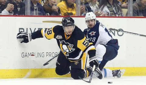 Feb 16, 2017; Pittsburgh, PA, USA; Pittsburgh Penguins defenseman Kris Letang (58) reaches for the puck against Winnipeg Jets left wing Nic Petan (19) during the second period at the PPG PAINTS Arena. Mandatory Credit: Charles LeClaire-USA TODAY Sports