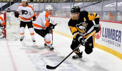 Kris Letang #58 of the Pittsburgh Penguins handles the puck against Robert Hagg #8 of the Philadelphia Flyers.